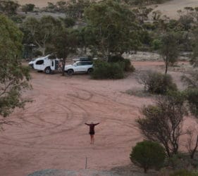 View to our camp and Leonie waving from top of Pildappa Rock, Minnipa, South Australia